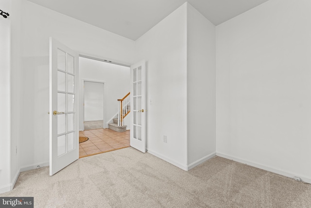 unfurnished room featuring light carpet and french doors