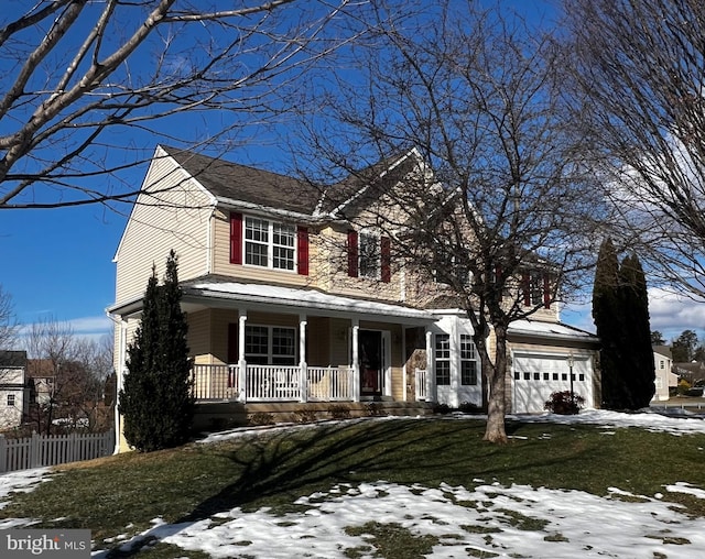 view of front of house with a garage, covered porch, and a lawn