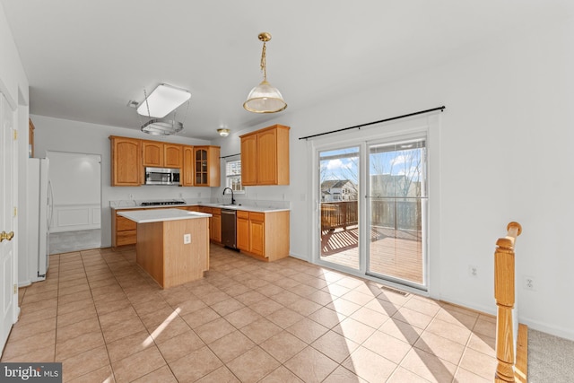 kitchen featuring a kitchen island, pendant lighting, sink, light tile patterned floors, and stainless steel appliances