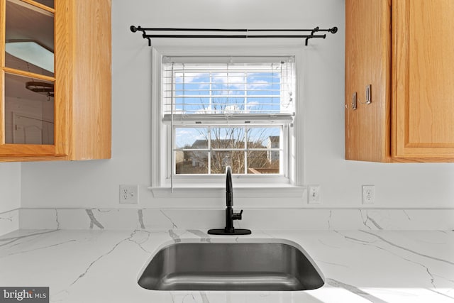 room details with light stone countertops and sink