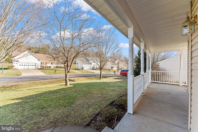 view of yard featuring a porch and a garage