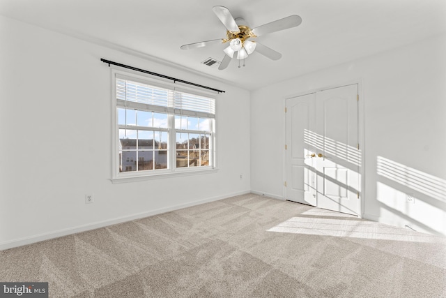 spare room with ceiling fan and light carpet