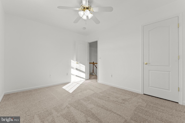 spare room with ceiling fan and light carpet