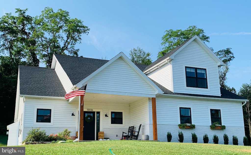 view of front of house with a front yard and covered porch