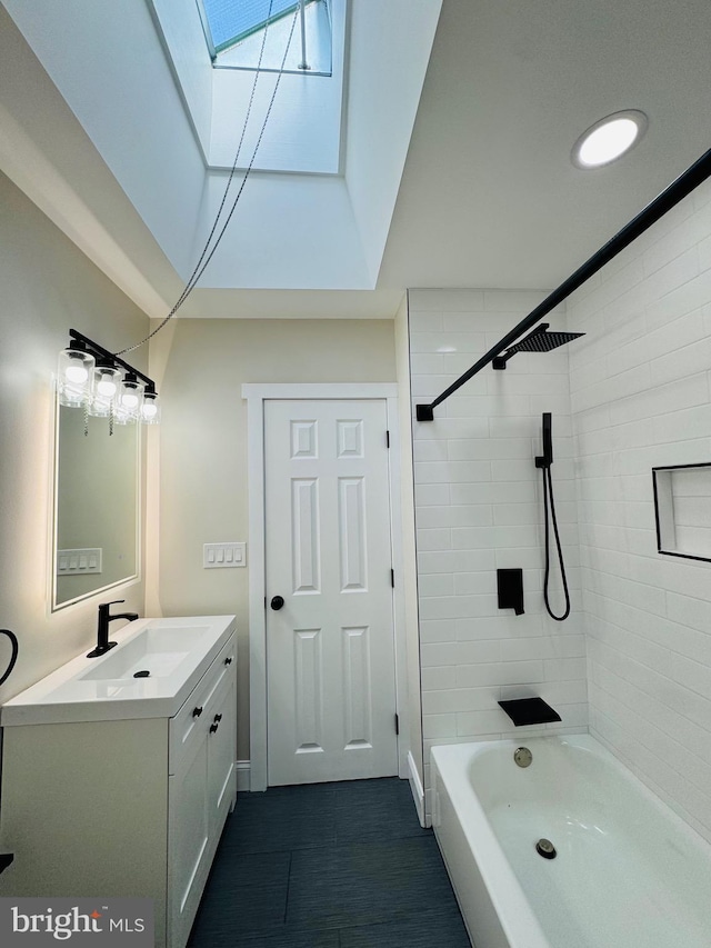 bathroom with tiled shower / bath, vanity, and a skylight