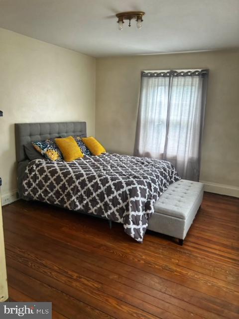 bedroom with dark hardwood / wood-style flooring