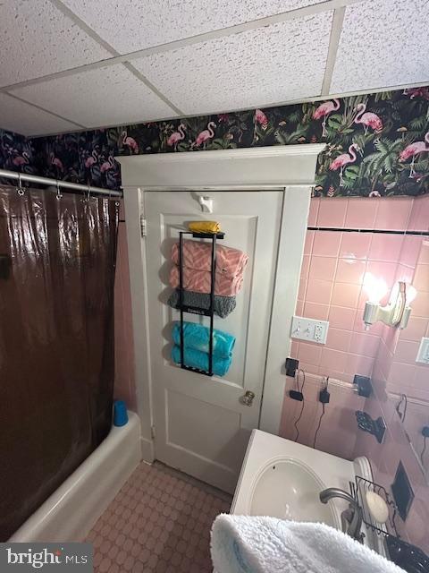 bathroom featuring a paneled ceiling and shower / bath combo