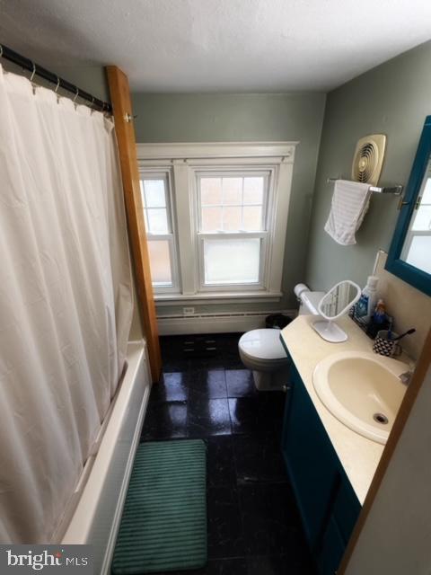 full bathroom with vanity, shower / tub combo, and toilet