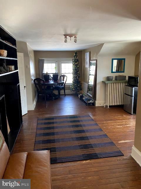 living room featuring dark wood-type flooring and radiator