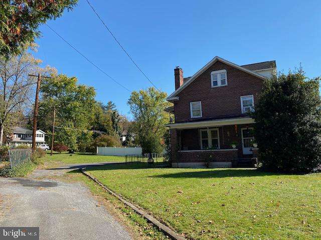 view of property exterior with a lawn and a porch