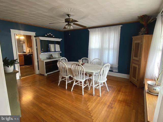 dining area with hardwood / wood-style floors and ceiling fan