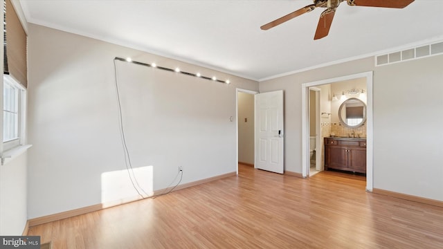 unfurnished bedroom with light wood finished floors, visible vents, crown molding, and baseboards