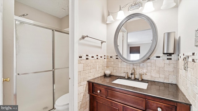 full bathroom featuring a shower stall, toilet, and vanity