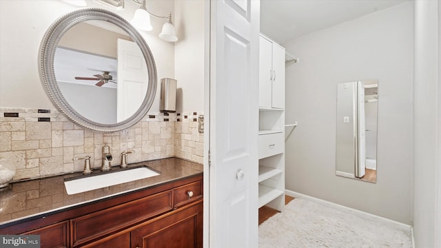 bathroom with baseboards, vanity, tasteful backsplash, and a ceiling fan