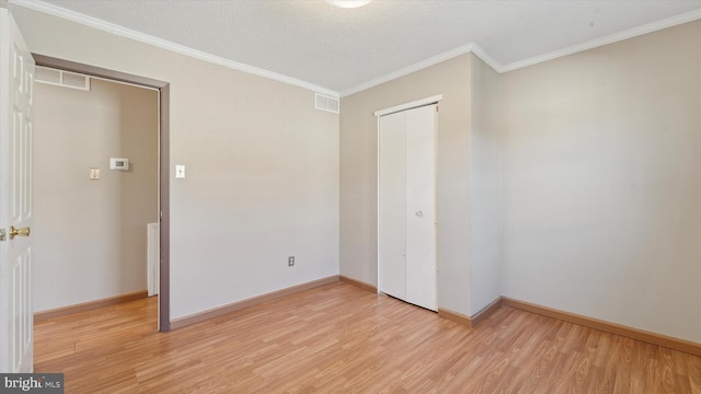 unfurnished bedroom with light wood-style flooring, visible vents, and ornamental molding