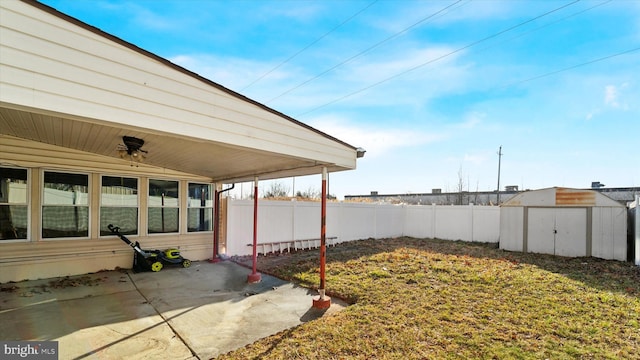 view of yard featuring an outbuilding, a storage unit, fence, and a patio