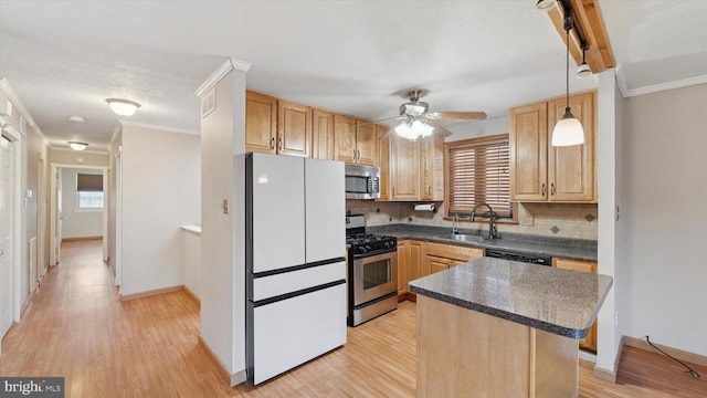 kitchen featuring dark countertops, ceiling fan, light wood-type flooring, appliances with stainless steel finishes, and a sink