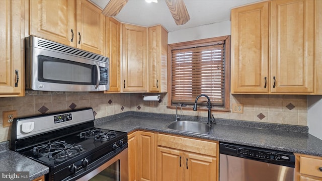 kitchen with dark countertops, ceiling fan, decorative backsplash, stainless steel appliances, and a sink