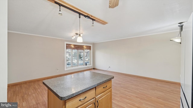 kitchen featuring dark countertops, light wood finished floors, and ornamental molding