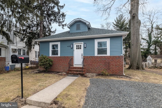 bungalow-style house featuring a front lawn