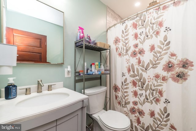 bathroom with vanity, curtained shower, and toilet