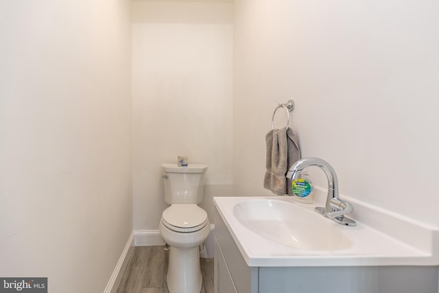 bathroom featuring vanity, wood-type flooring, and toilet