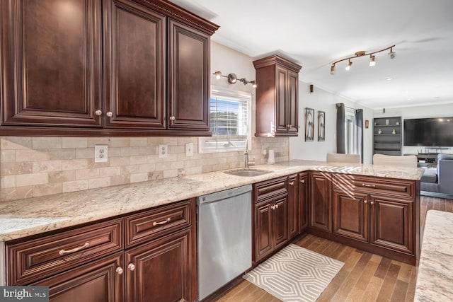 kitchen with dishwasher, light stone countertops, sink, and kitchen peninsula