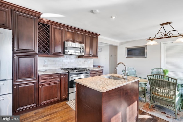 kitchen with pendant lighting, decorative backsplash, stainless steel appliances, crown molding, and light stone countertops