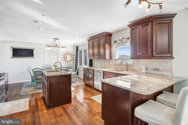 kitchen with decorative light fixtures, stainless steel dishwasher, dark hardwood / wood-style floors, a kitchen island, and backsplash