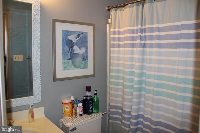 bathroom with sink, a shower with shower curtain, and toilet