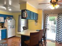 kitchen featuring a breakfast bar, ceiling fan, white refrigerator, blue cabinets, and kitchen peninsula