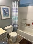 full bathroom with shower / tub combo with curtain, vanity, and toilet