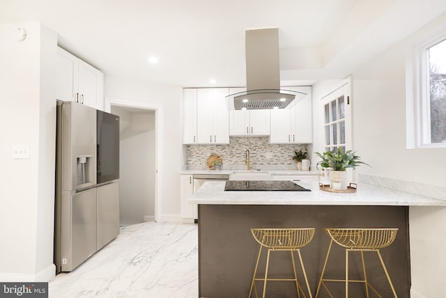 kitchen featuring white cabinetry, island range hood, a kitchen breakfast bar, and appliances with stainless steel finishes