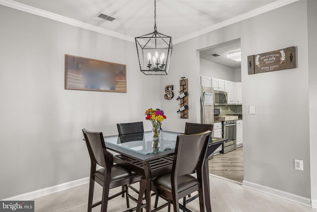 dining space with ornamental molding and light hardwood / wood-style floors