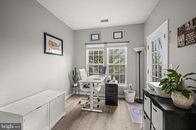 office with hardwood / wood-style floors and a textured ceiling