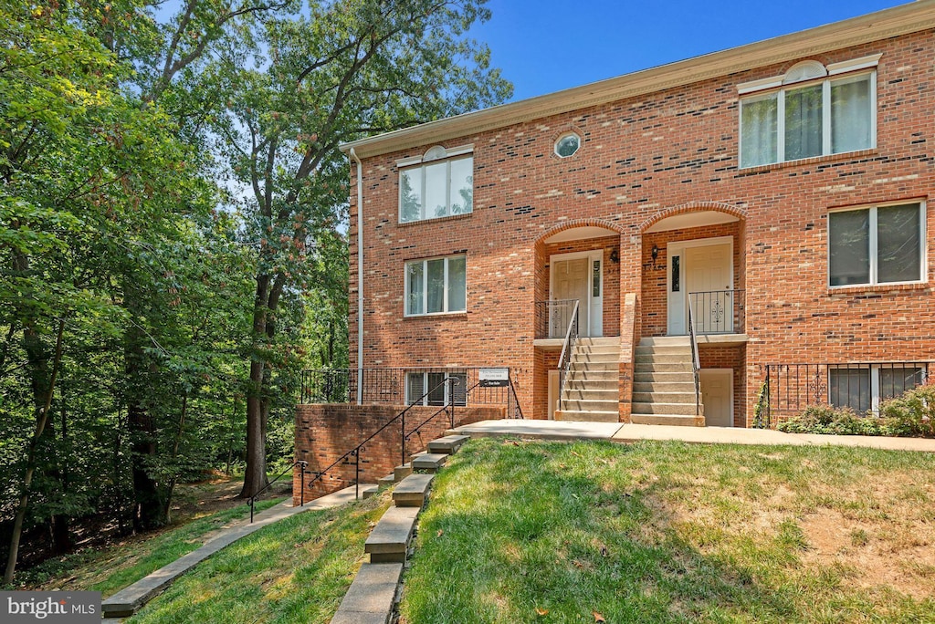 multi unit property featuring a front yard and a porch