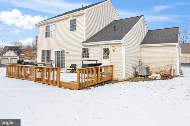 snow covered back of property with a wooden deck and central air condition unit