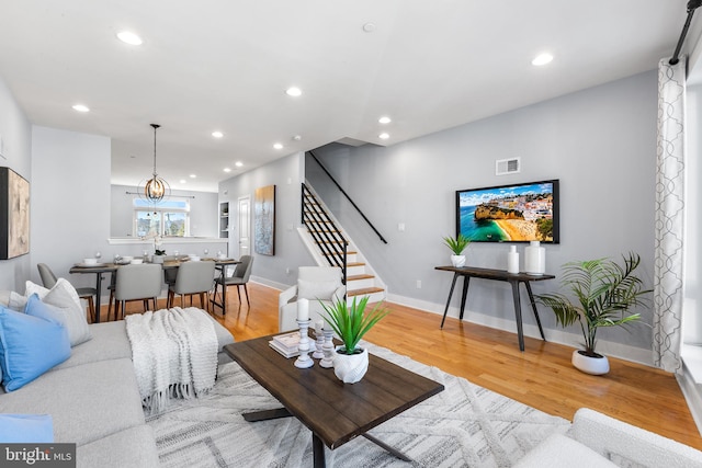 living room with an inviting chandelier and light wood-type flooring