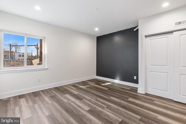 unfurnished bedroom with dark wood-type flooring and a closet