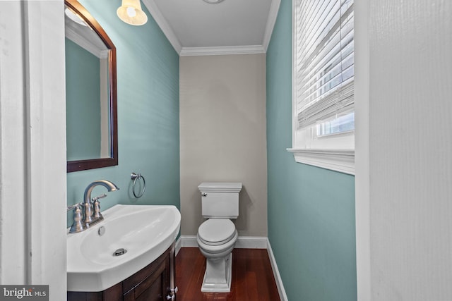 bathroom with ornamental molding, toilet, sink, and hardwood / wood-style floors