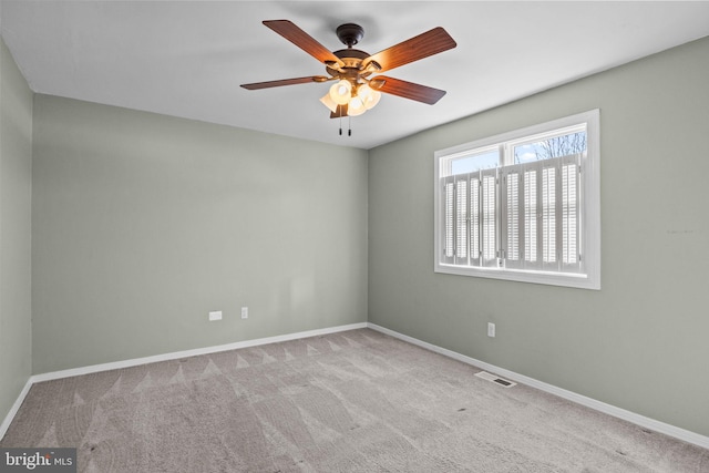 carpeted spare room with ceiling fan