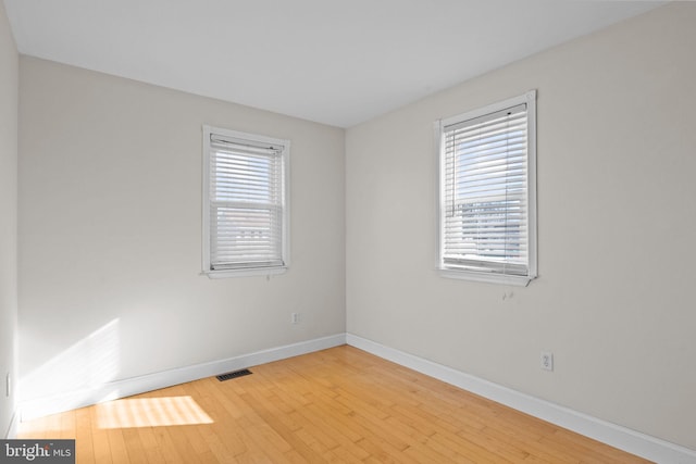 empty room featuring plenty of natural light and hardwood / wood-style floors