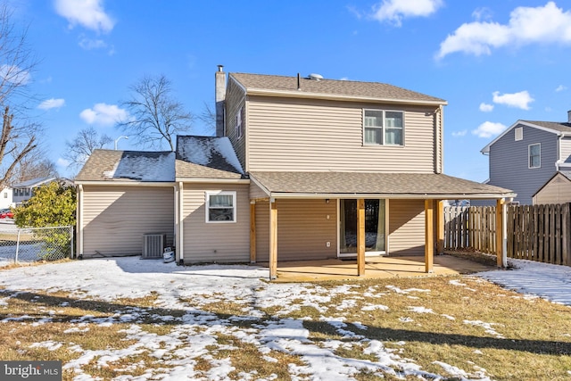 snow covered rear of property with central AC