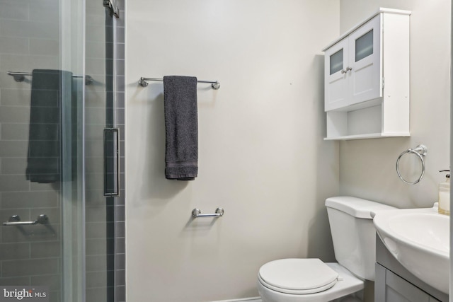 bathroom with vanity, a shower with shower door, and toilet