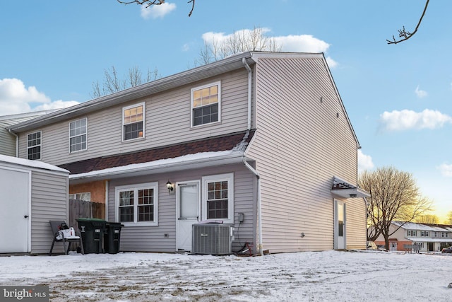 snow covered house with central air condition unit