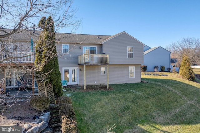 back of house featuring a balcony and a yard