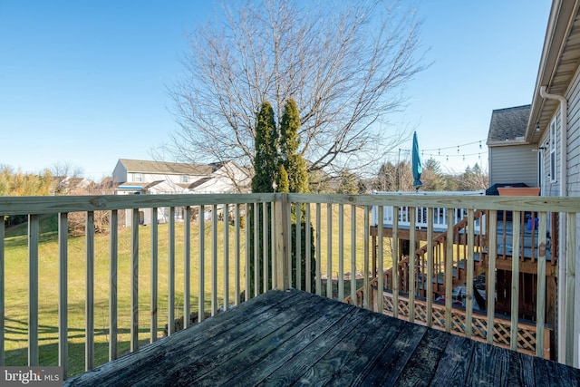 wooden deck featuring a lawn