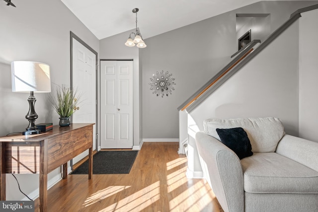 foyer entrance with wood-type flooring and vaulted ceiling