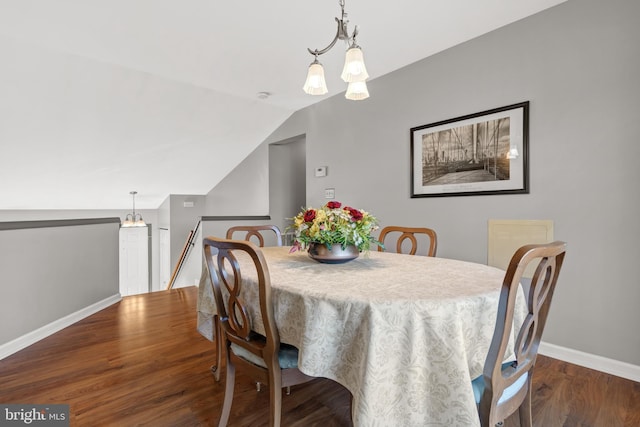 dining space featuring vaulted ceiling and dark hardwood / wood-style flooring