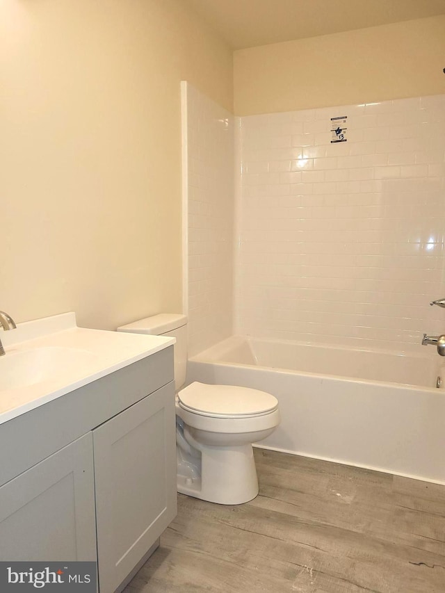 full bathroom featuring wood-type flooring, toilet, shower / bath combination, and vanity